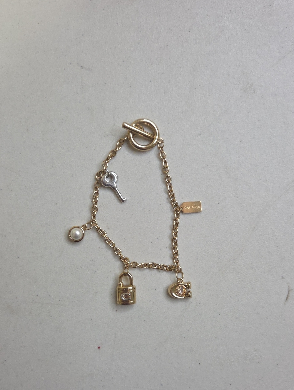 Coach Gold Charm Bracelet with Pearl, Key, Lock and Tag